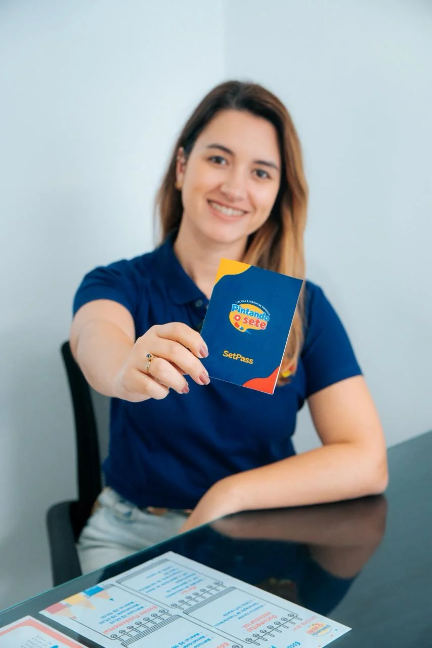 Profissional da Escola Pintando o Sete apresentando material institucional